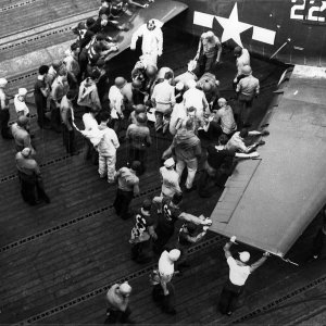 Flight deck personnel attend to a wounded aviator of VF 19 F6F 5 Hellcat Lexington CV 16 Battle