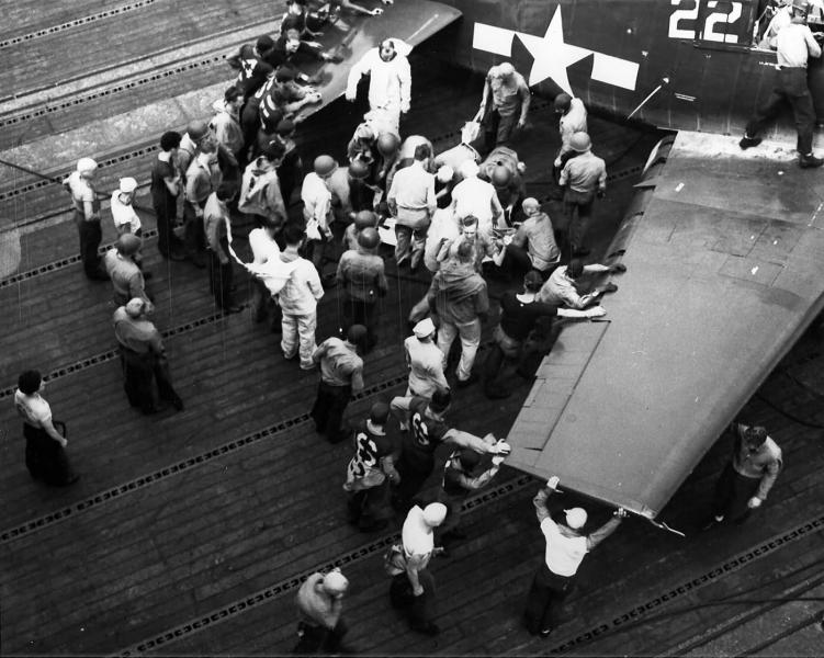 Flight deck personnel attend to a wounded aviator of VF 19 F6F 5 Hellcat Lexington CV 16 Battle